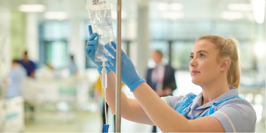 person with blue gloves checking iv bag
